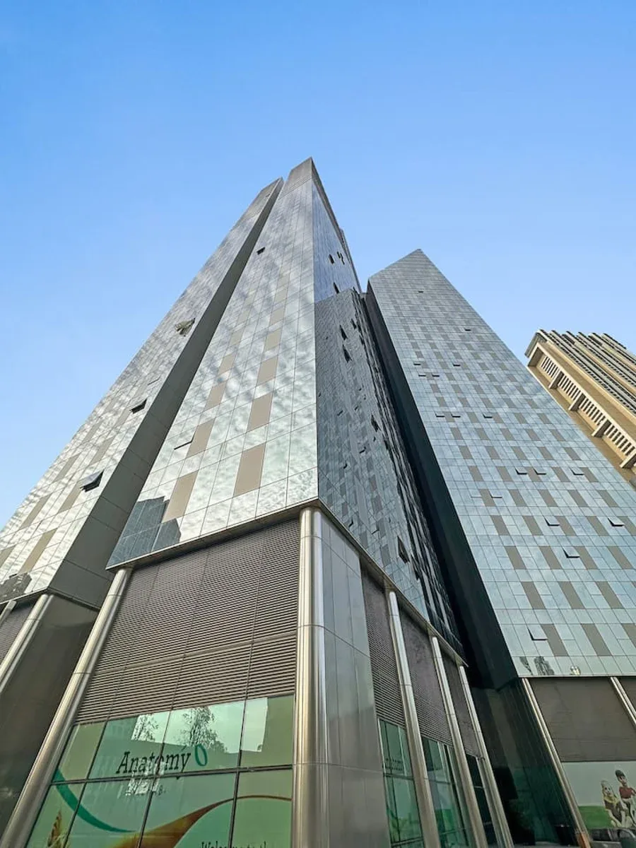 Un edificio moderno de gran altura se alza contra un cielo azul despejado.