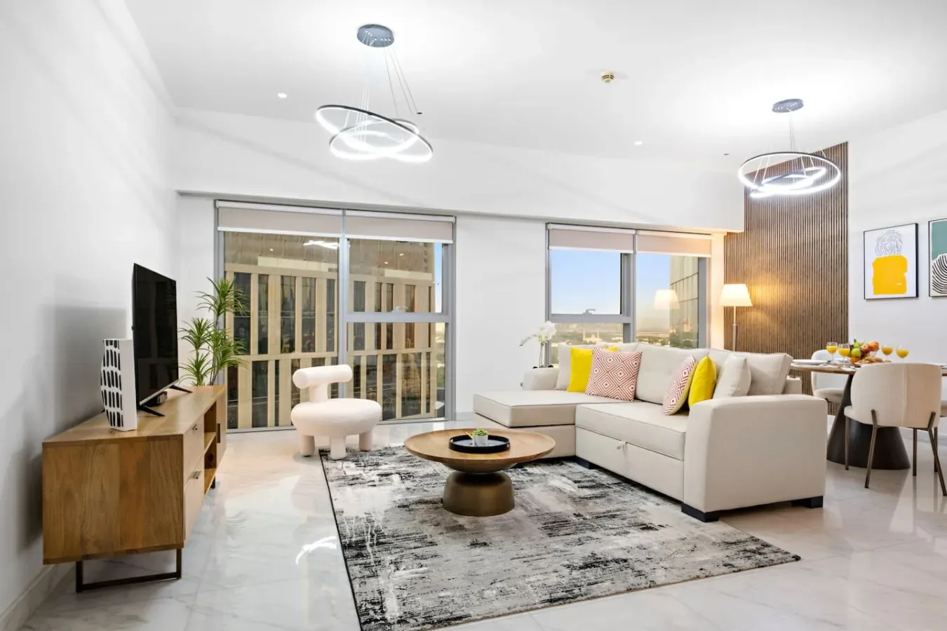 Una sala luminosa con zona de estar, mesa de centro y grandes ventanas.