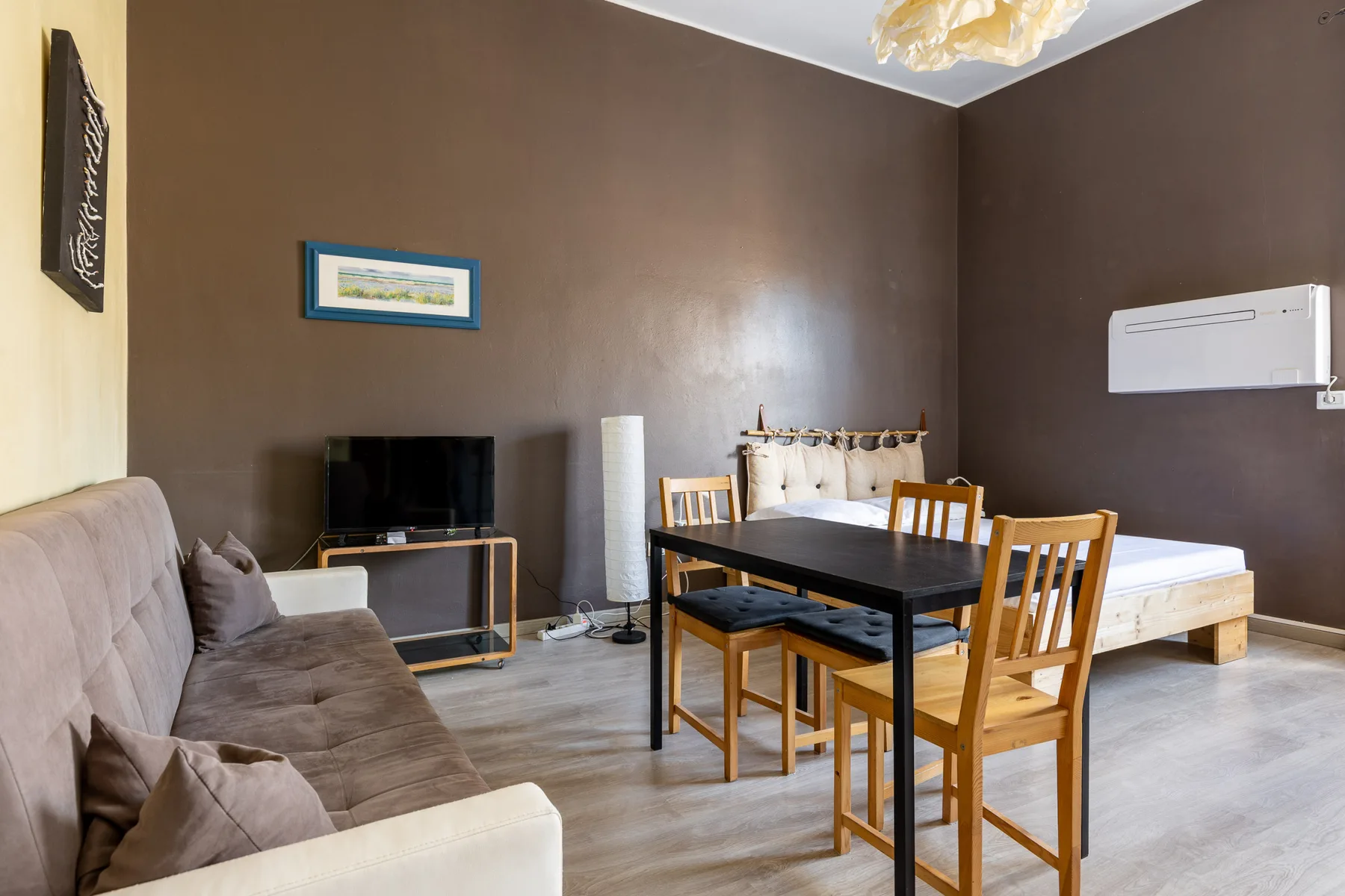 Una sala y comedor integrados con sofá, mesa y televisor.