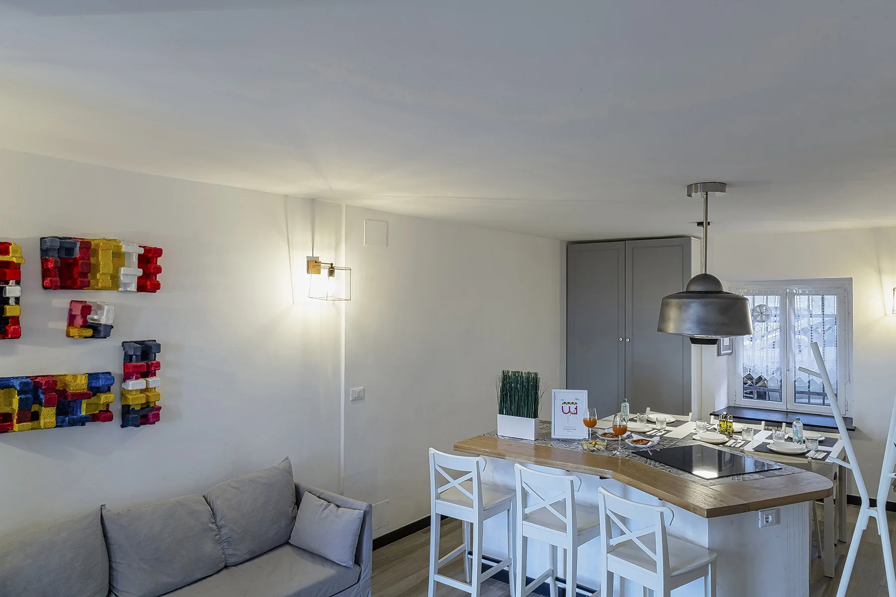 Un comedor con una mesa y sillas junto a estantes coloridos en la pared.