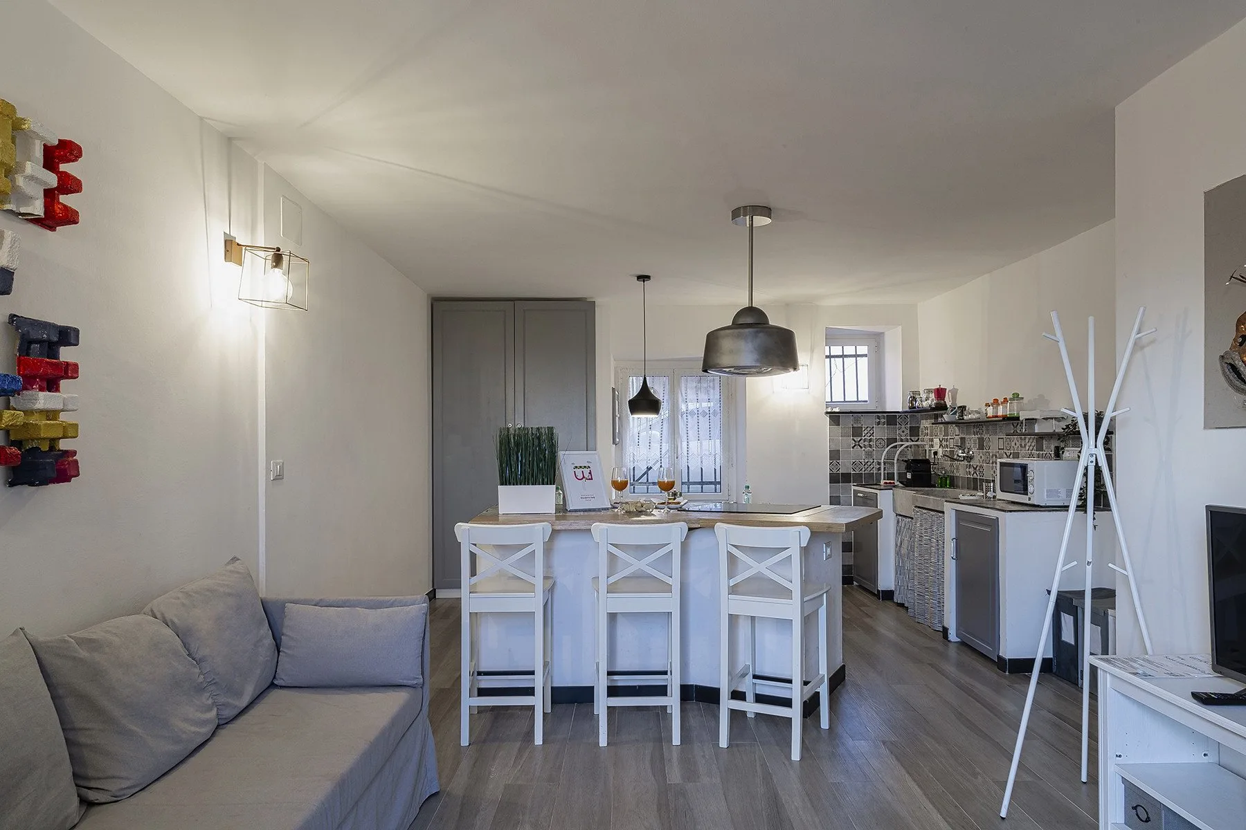 Una zona abierta de sala y cocina con un sofá y una barra para desayunar.