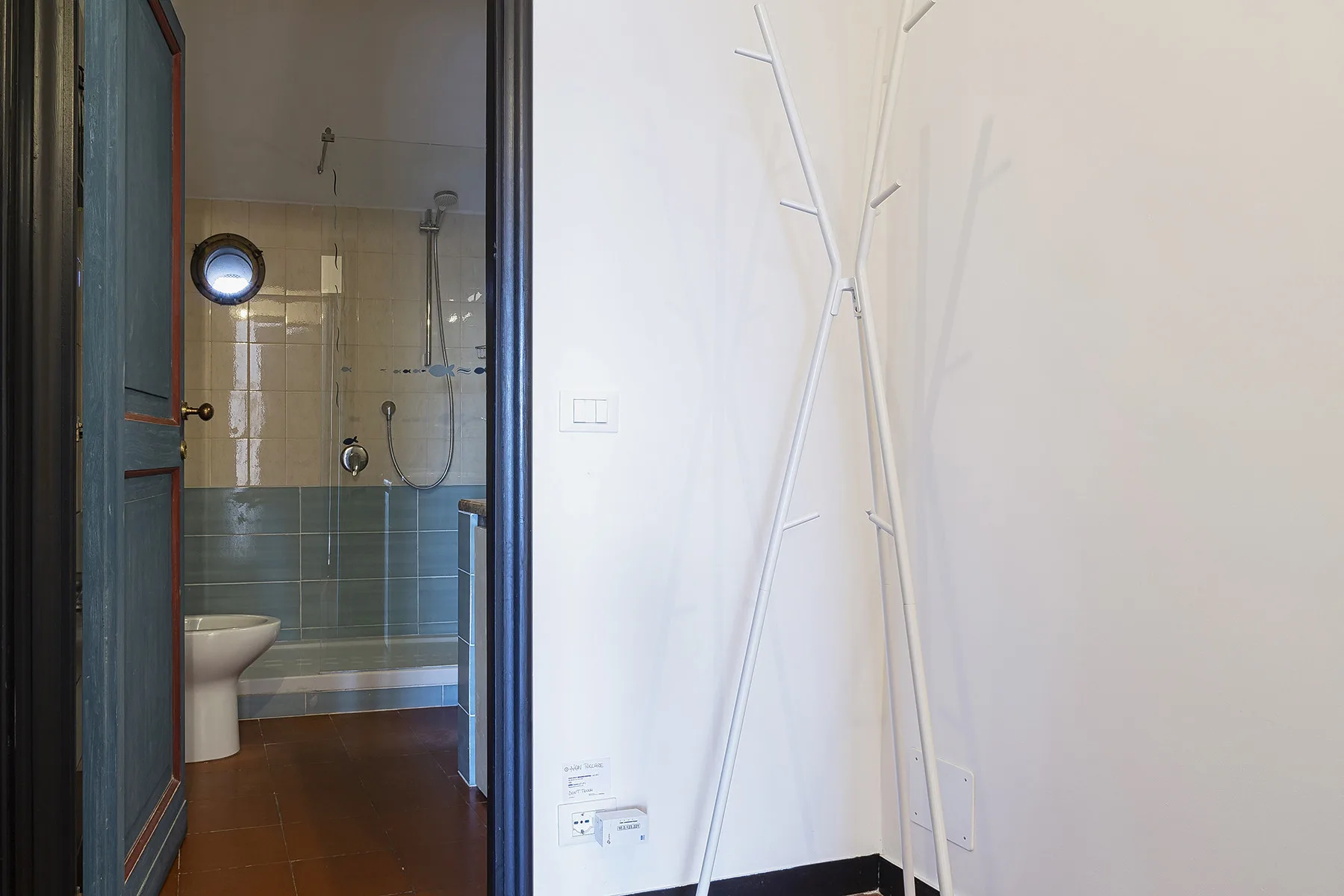 A bathroom with a shower is visible through the open doorway.