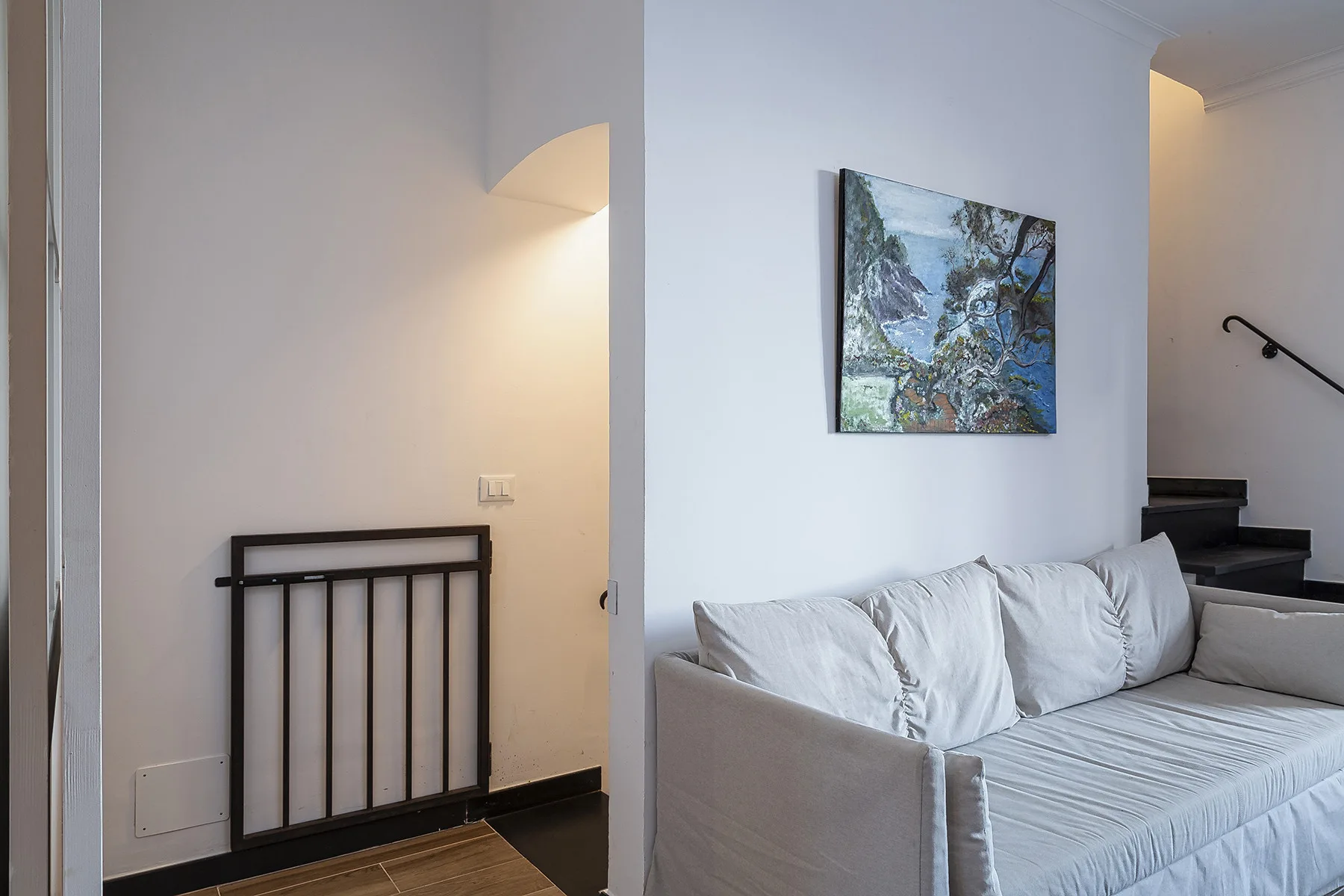 A living room with a light-colored sofa and framed artwork on the wall.