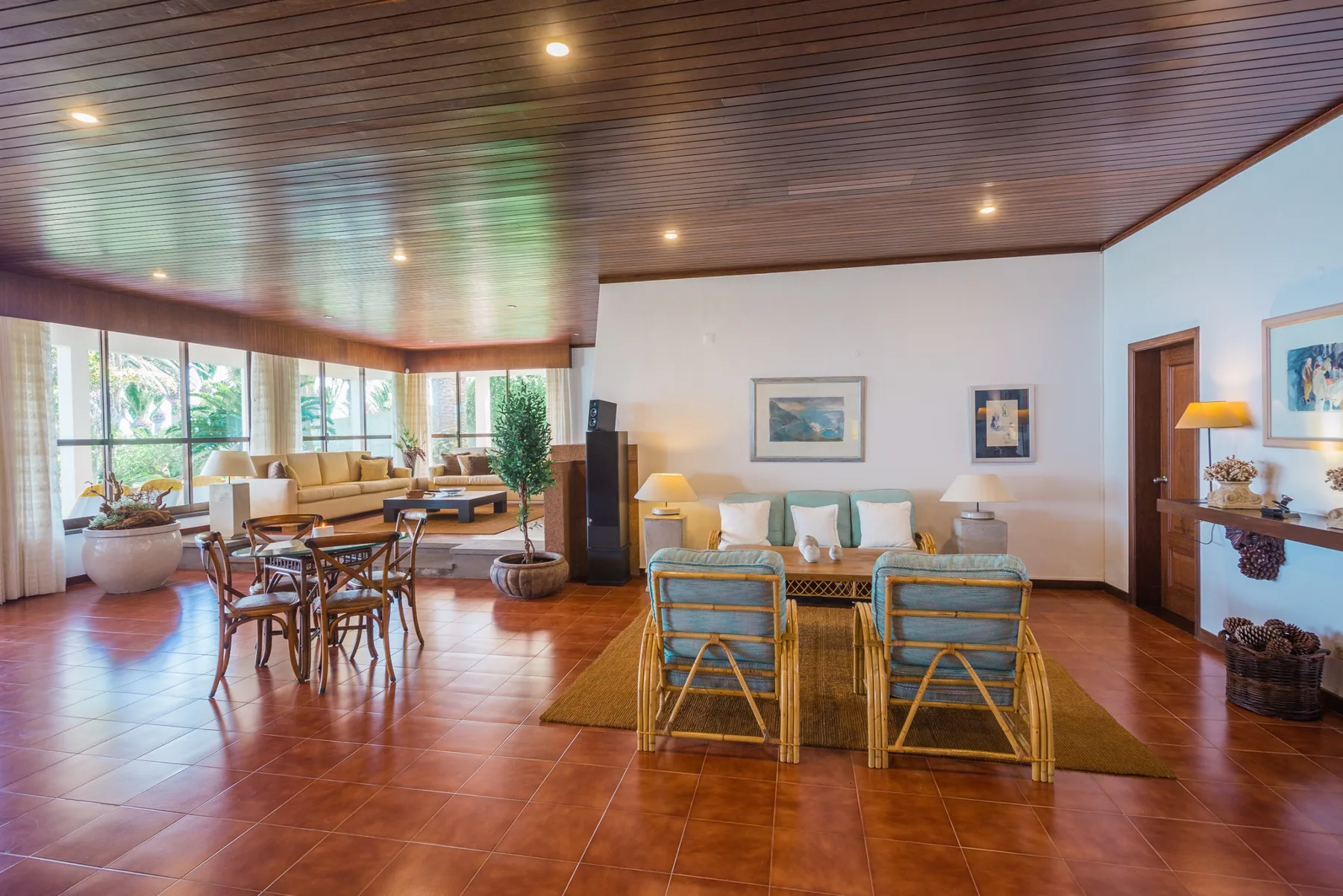 Una sala de estar amplia con comedor y grandes ventanas.