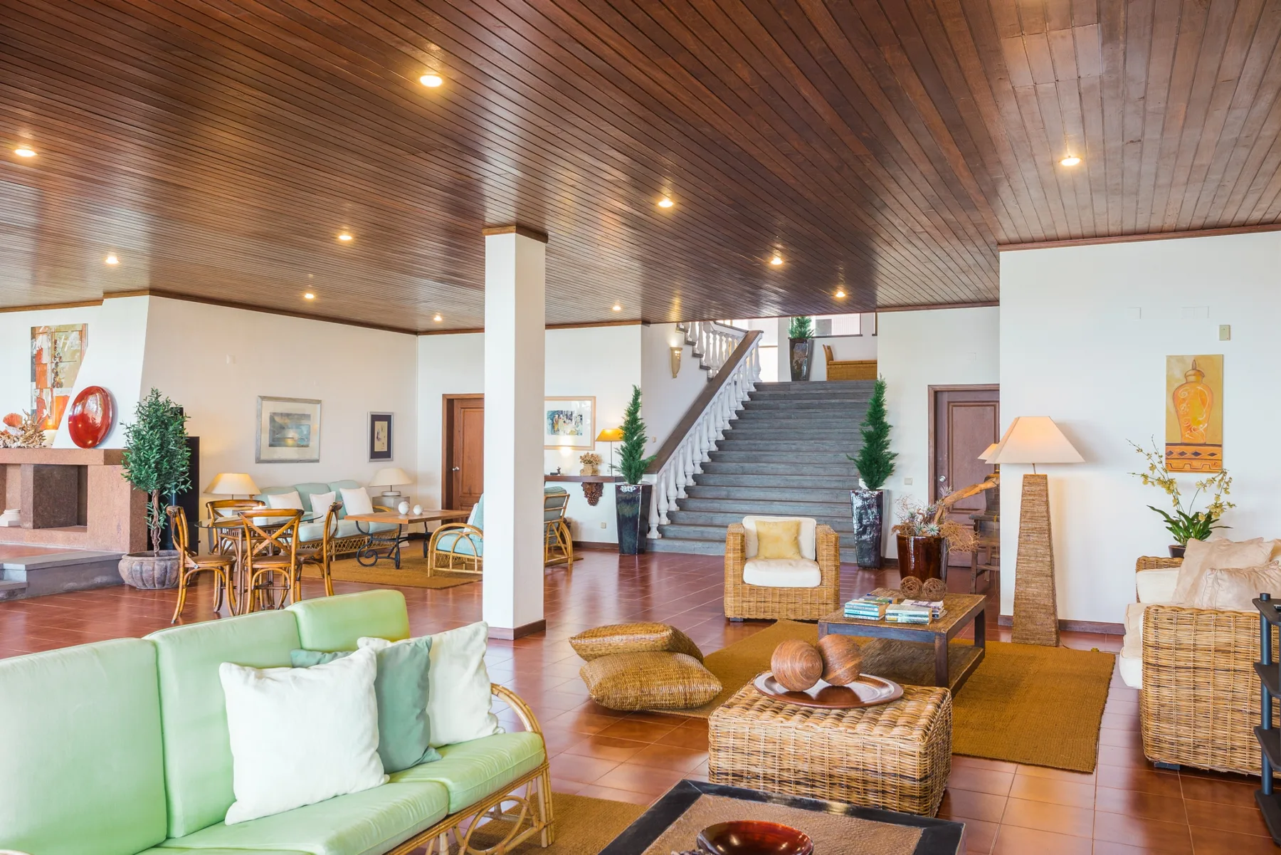Sala de estar con zonas de asiento, una chimenea y una escalera.