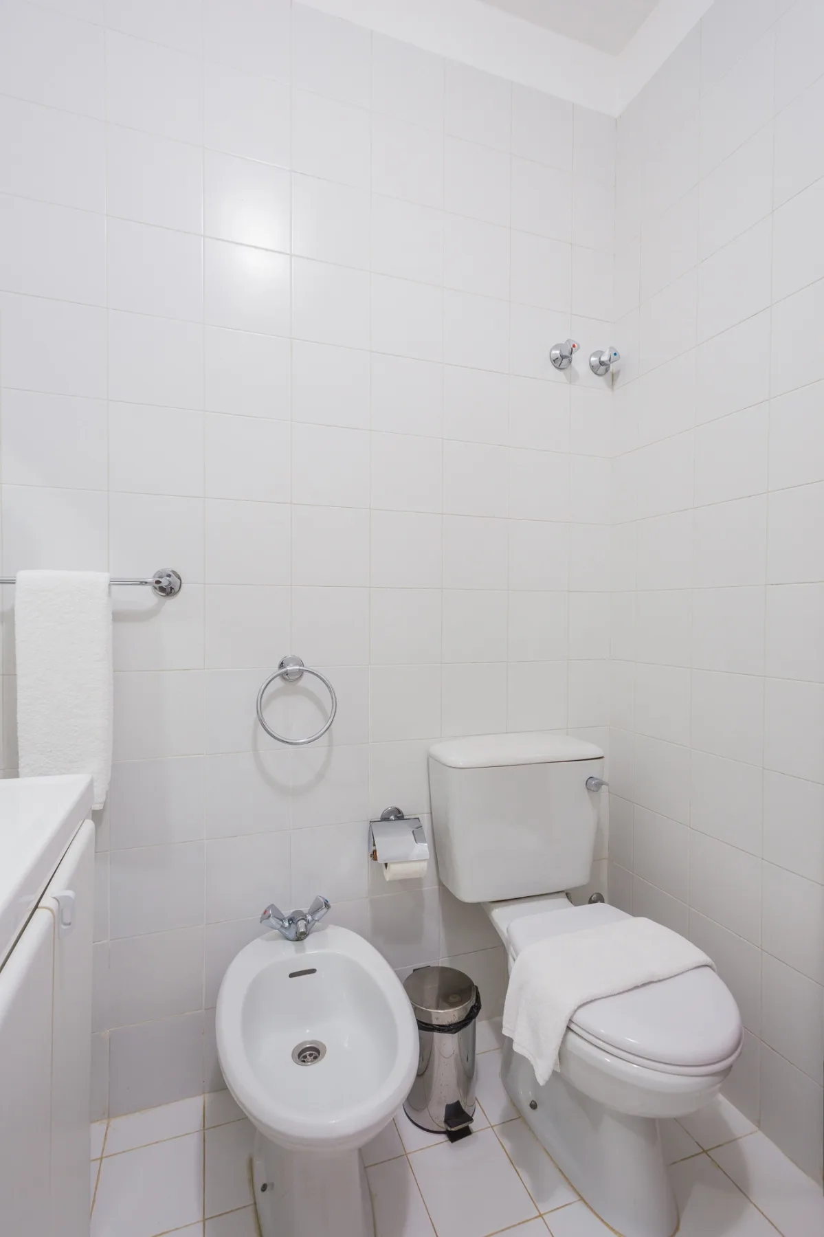 Un baño con azulejos, inodoro y bidé.
