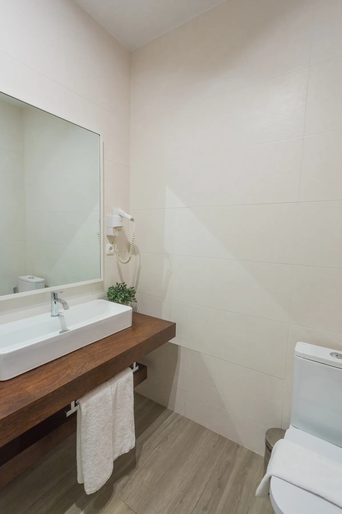 Un baño con lavabo, espejo, ducha e inodoro.