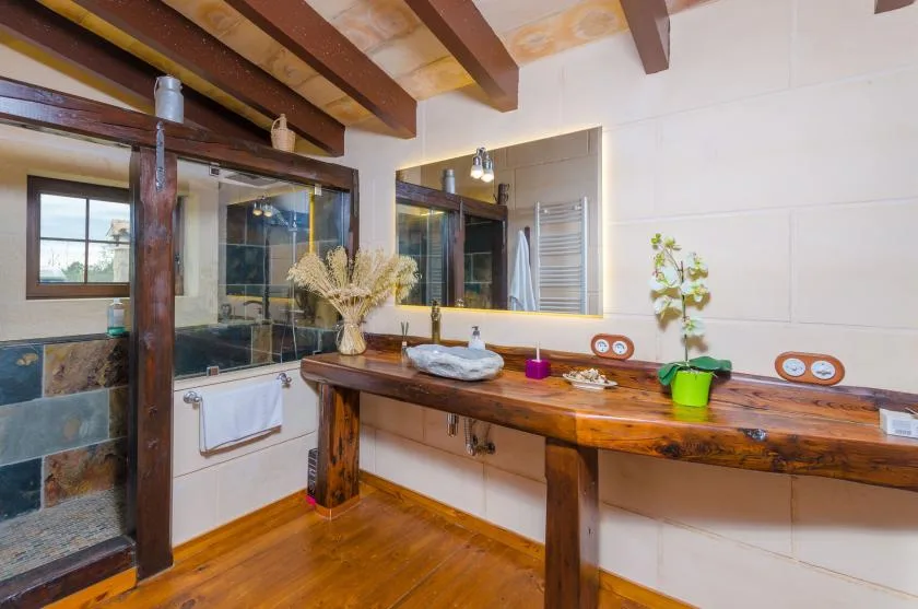 Un tocador de baño con una larga encimera de madera y lavabos.
