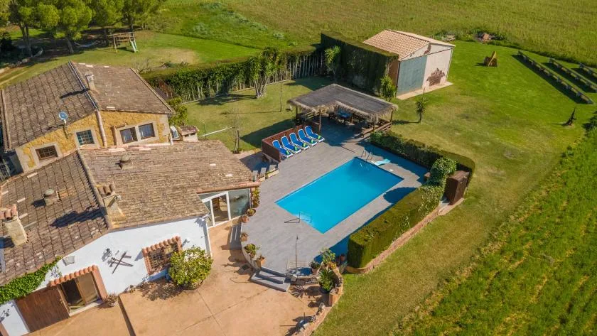 Vista aérea de una propiedad rural con piscina y césped alrededor.