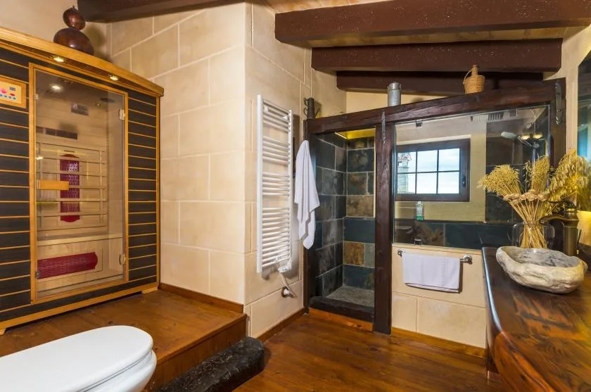Un baño con ducha acristalada, bañera y tocador de madera.