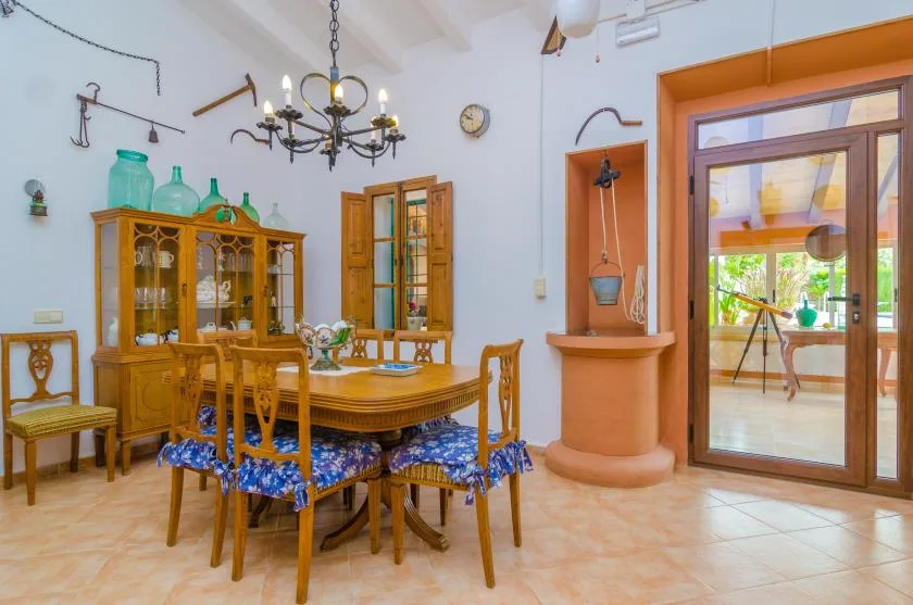 Un comedor con una mesa de madera y una vitrina.