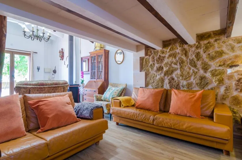Una sala de estar con asientos de cuero y una pared de piedra vista.