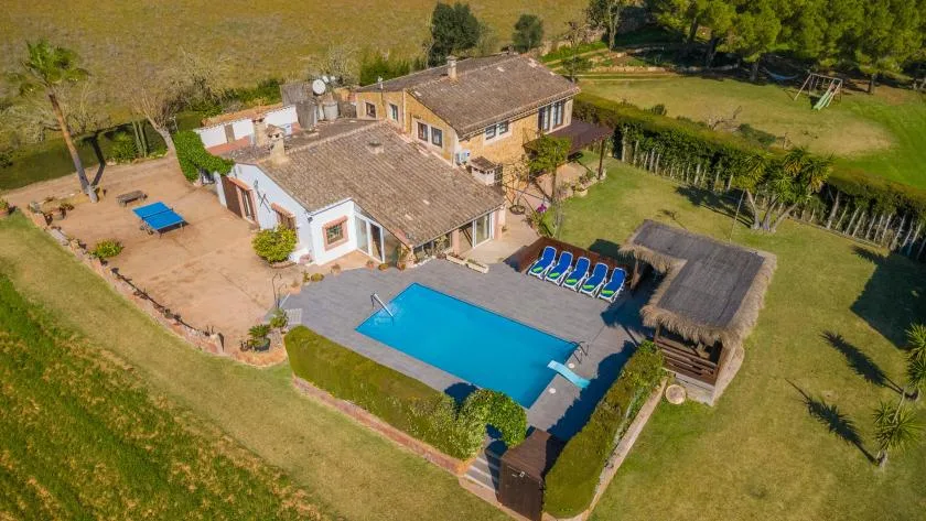 An aerial view of a house, swimming pool, and surrounding lawn.