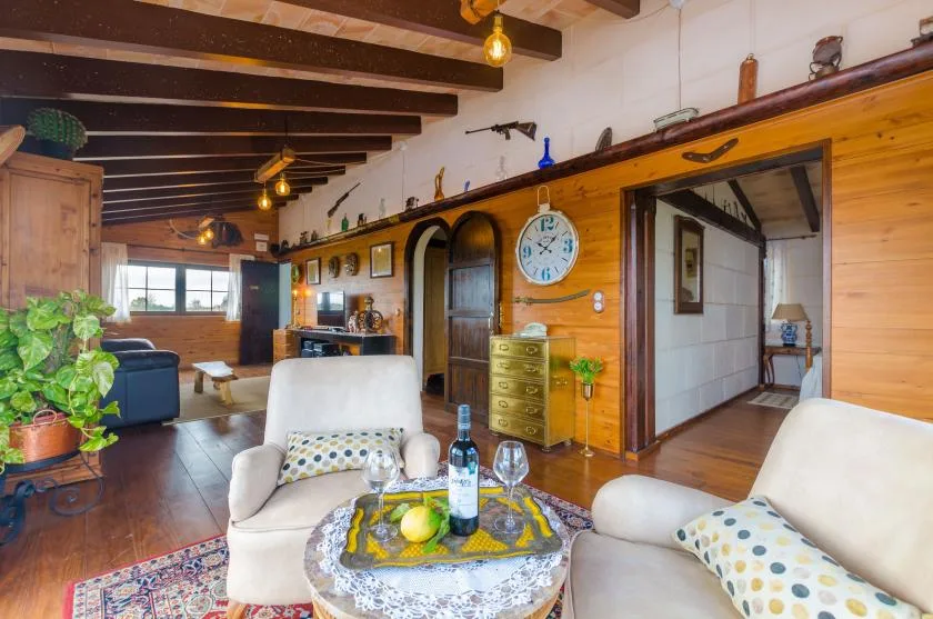 Una sala acogedora con asientos alrededor de una mesa pequeña y vigas de madera expuestas.