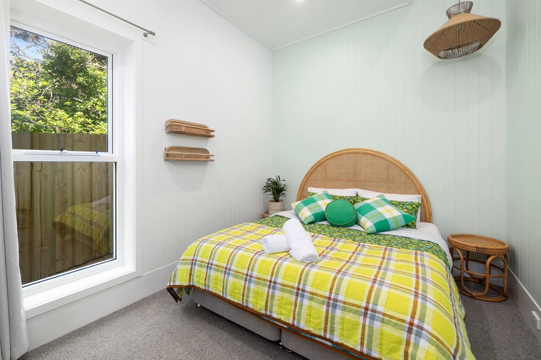 Un dormitorio con una cama cubierta con una colcha de cuadros amarillos.
