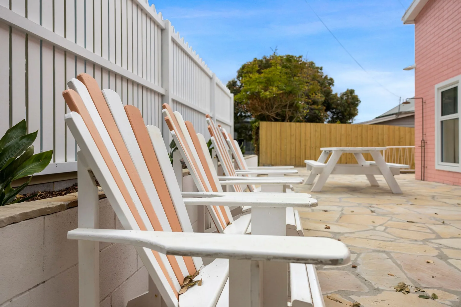 Un patio al aire libre tiene asientos a rayas y una mesa de picnic.