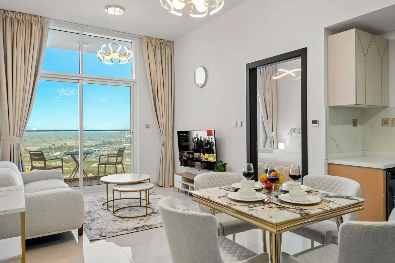 A bright living and dining area with large windows, seating, and a dining table.