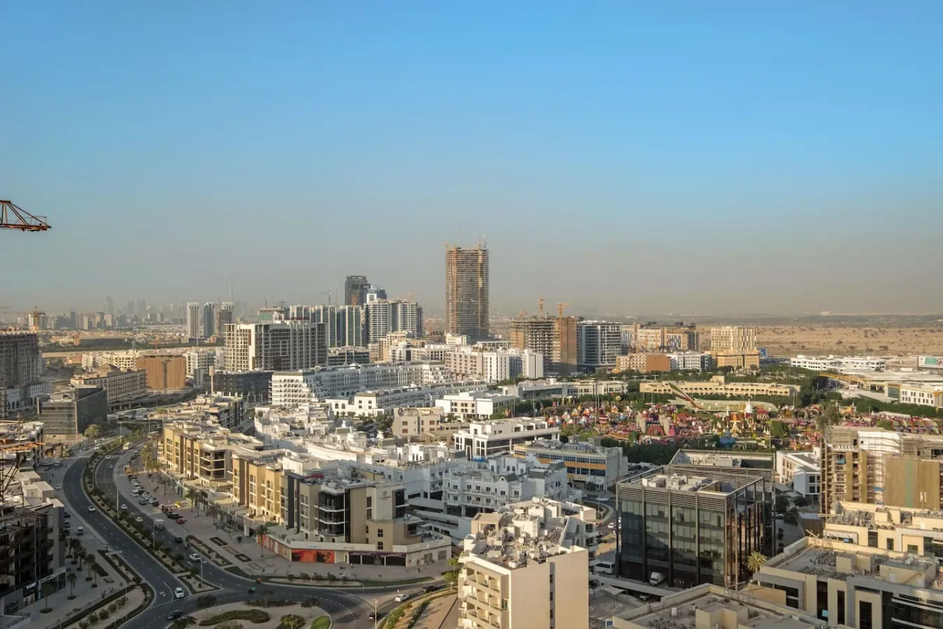 A cityscape of low-rise buildings and roads beneath a clear sky.