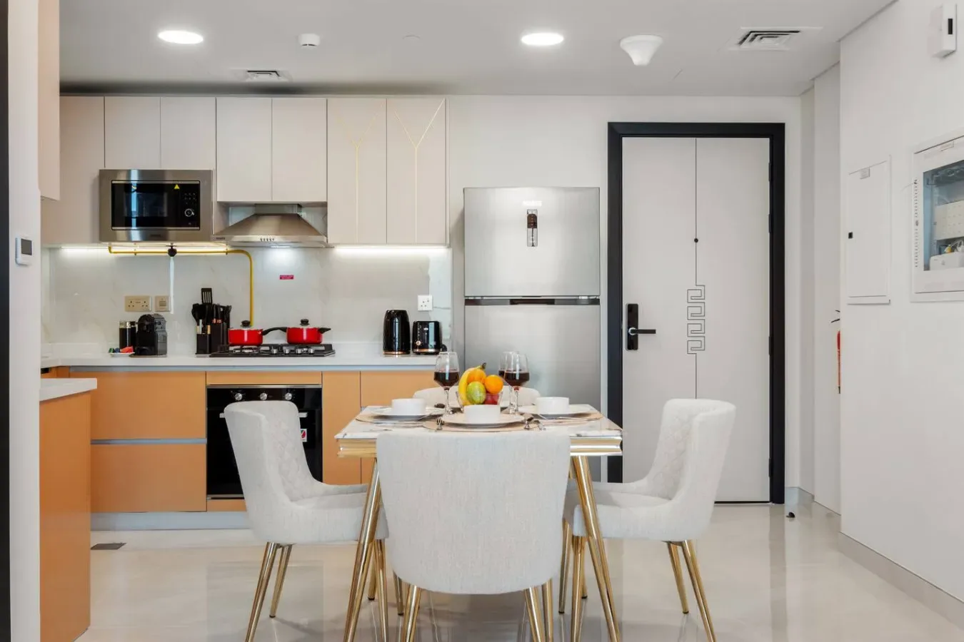 A dining area with a set table and seating beside a kitchen.