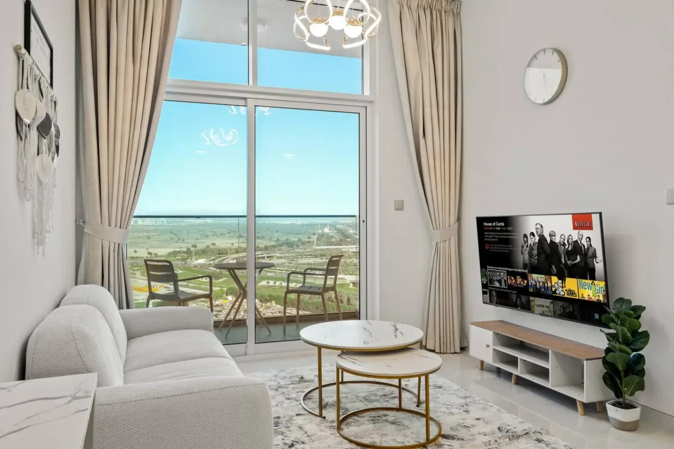 A bright living room with seating and large windows overlooking the landscape.