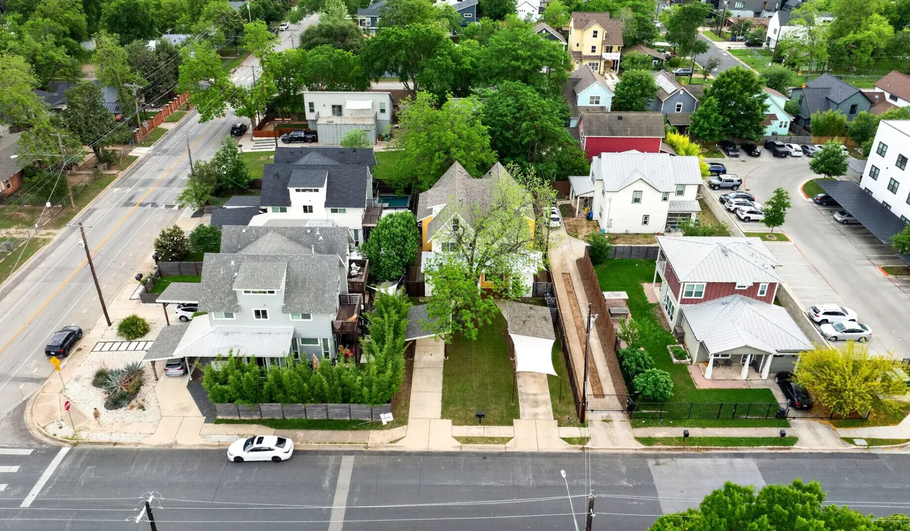 Aerial view of a leafy residential neighborhood with houses along intersecting streets.