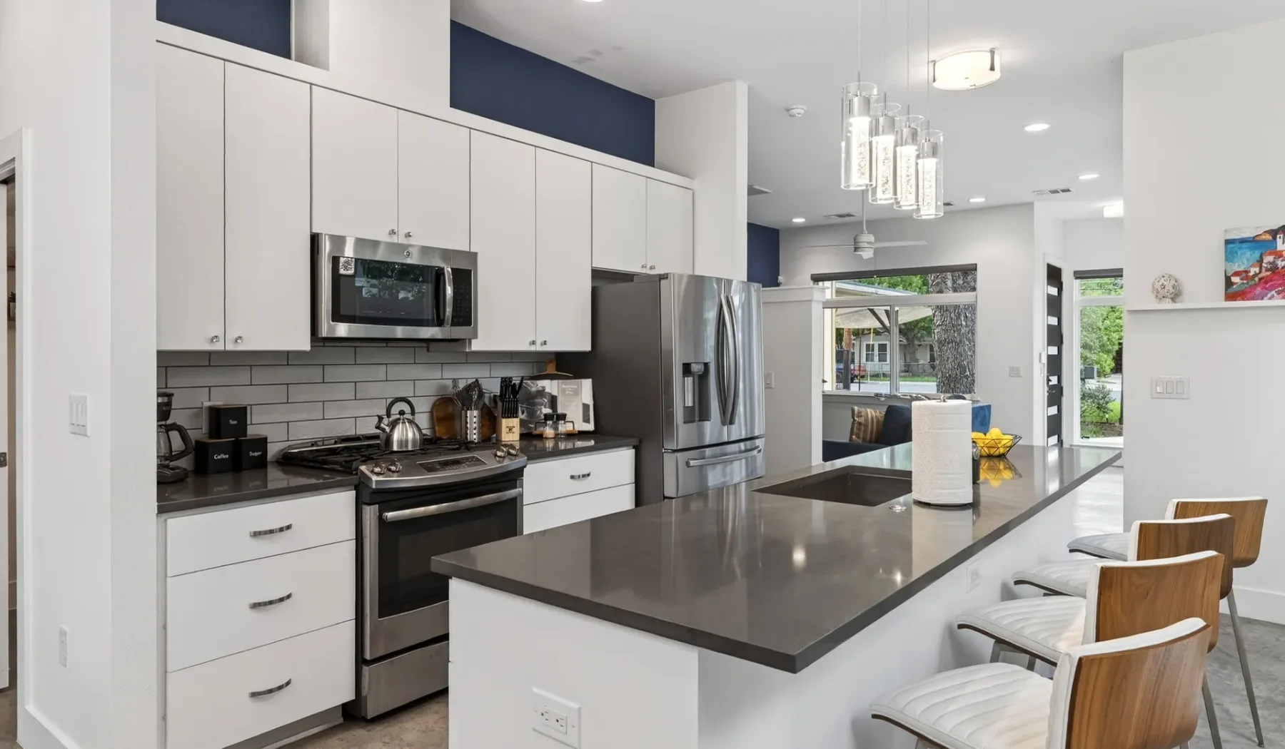 A bright modern kitchen with white cabinetry and a large island.