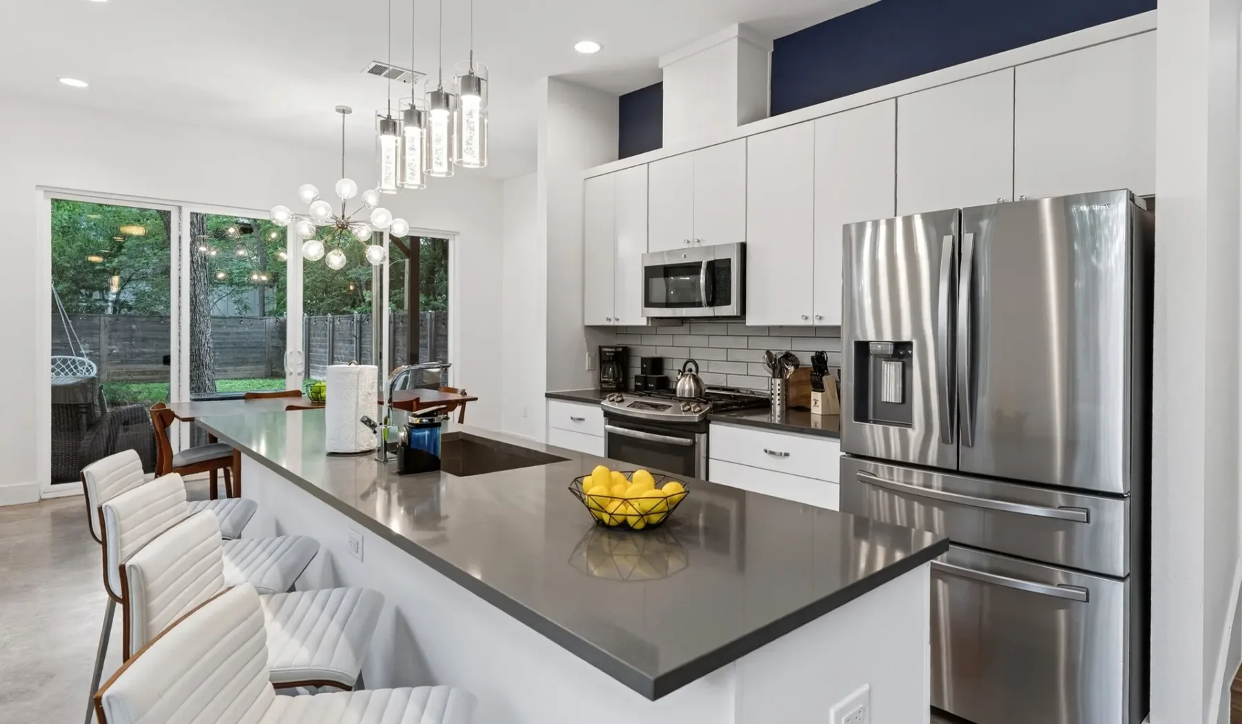 A bright modern kitchen with a large island and stainless steel appliances.
