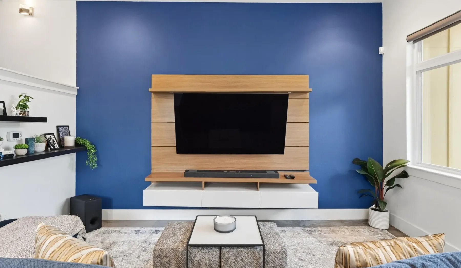 A living room with a television mounted on a wood-paneled wall.