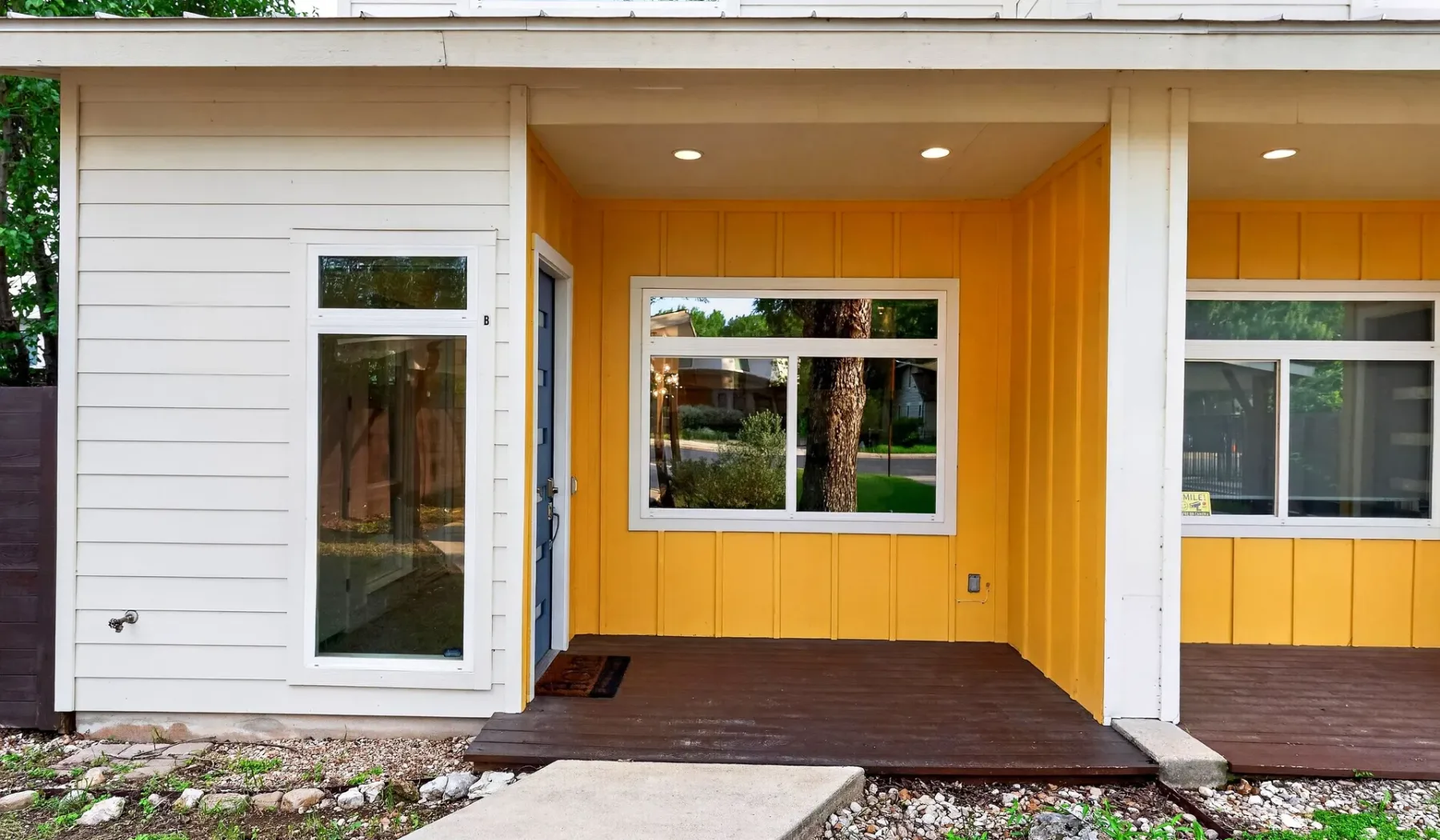 A house entrance with a yellow recessed entry and windows.