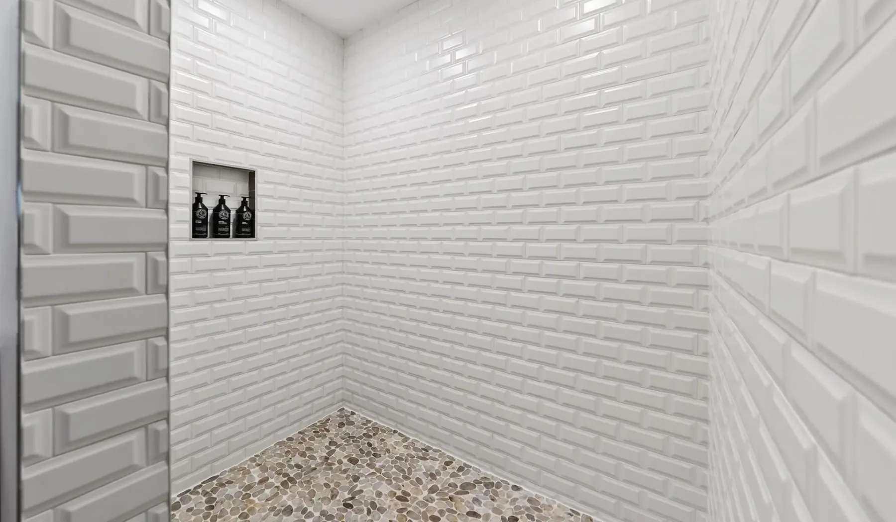 A tiled shower area with a small recessed shelf and mosaic flooring.