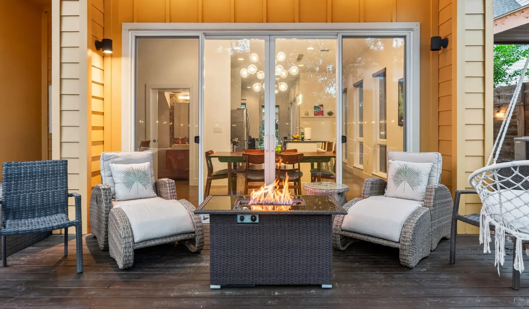 An outdoor seating area with cushioned lounge chairs around a fire table.