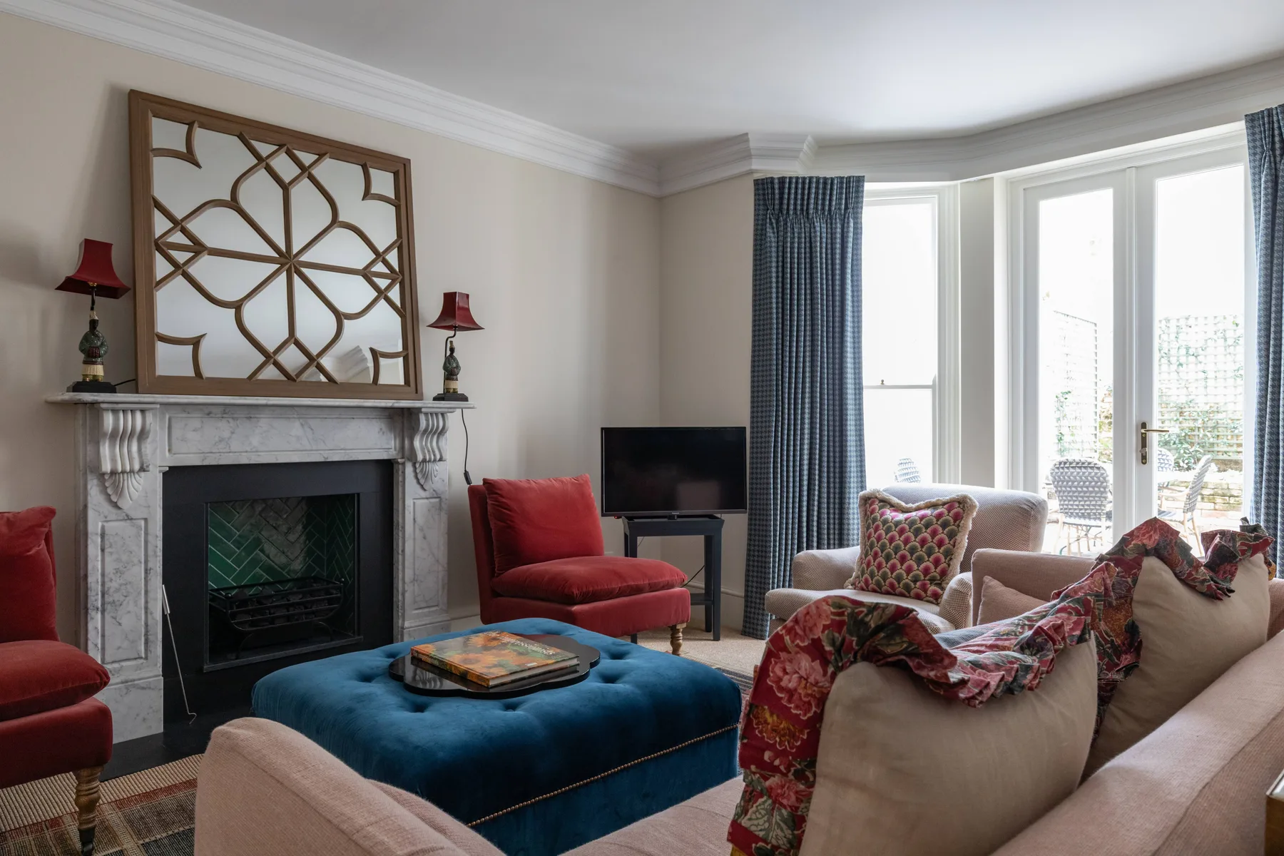 A living room with a fireplace, seating, and large windows.