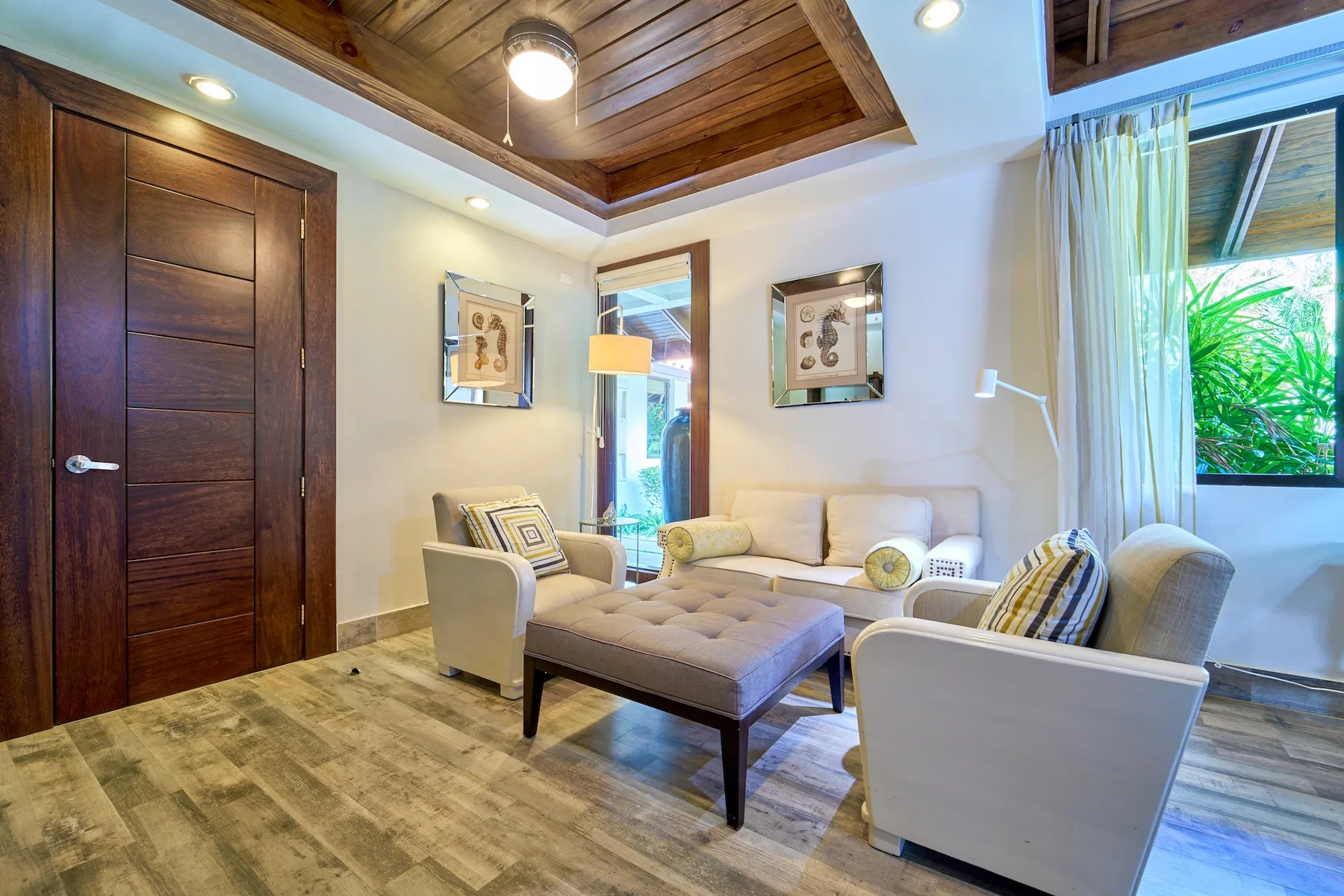 Una sala de estar luminosa con asientos acolchados y una ventana grande.