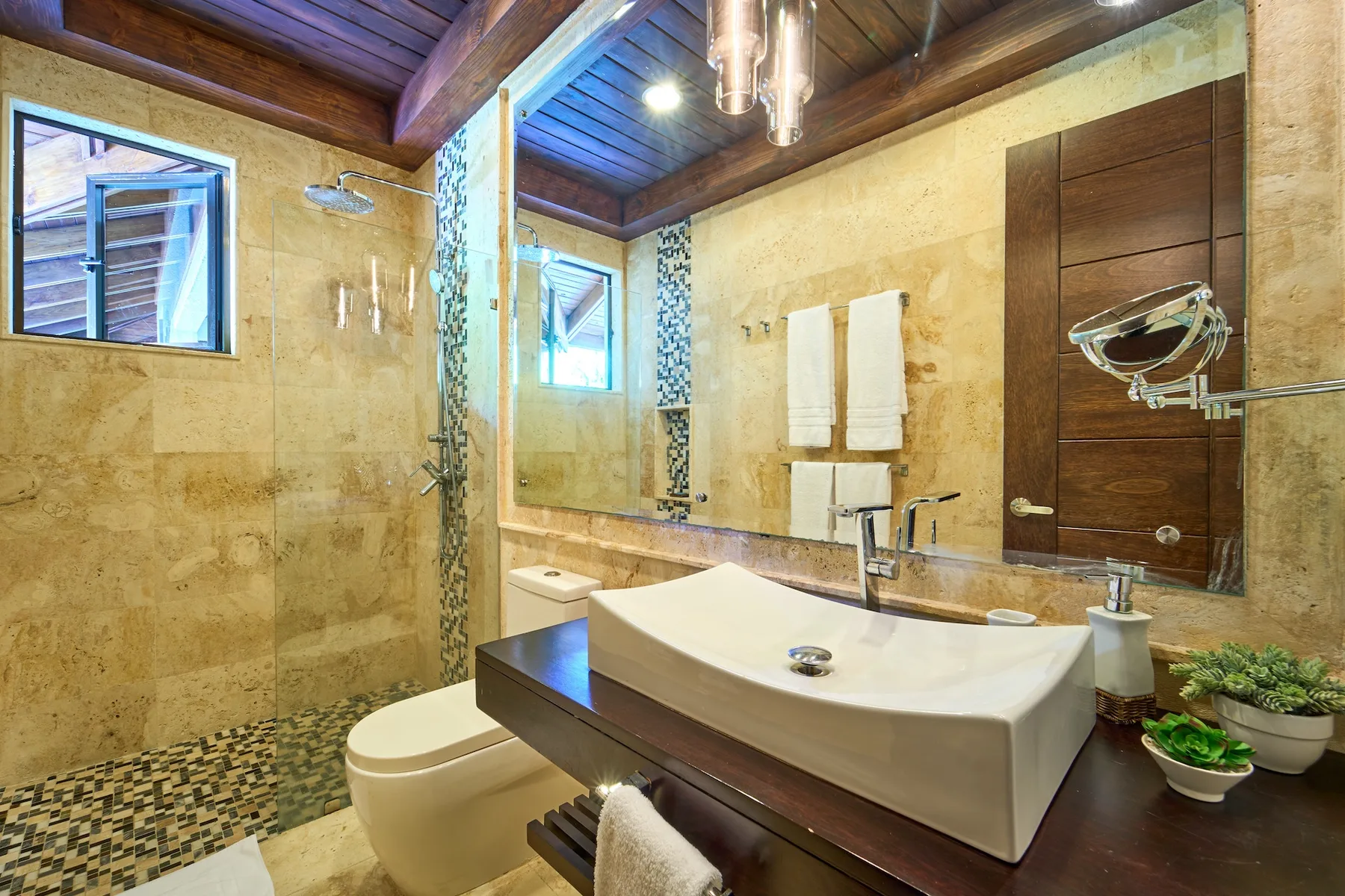 Un baño con un lavabo grande, un inodoro y una zona de ducha con azulejos.