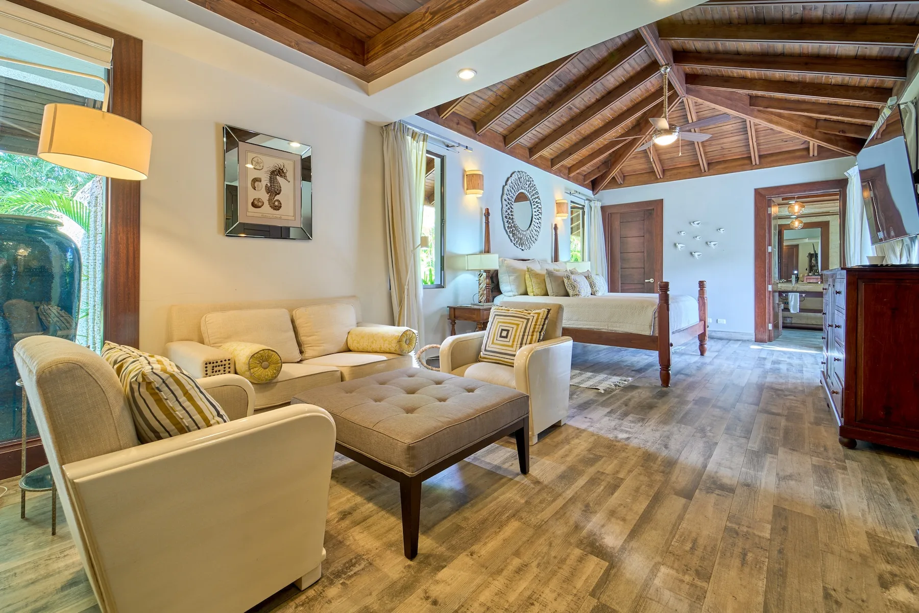 Una sala de estar con asientos acolchados y un techo con vigas de madera.