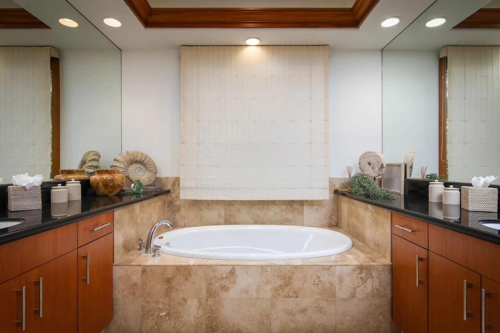 A bathroom with a built-in bathtub beneath a wide window shade.