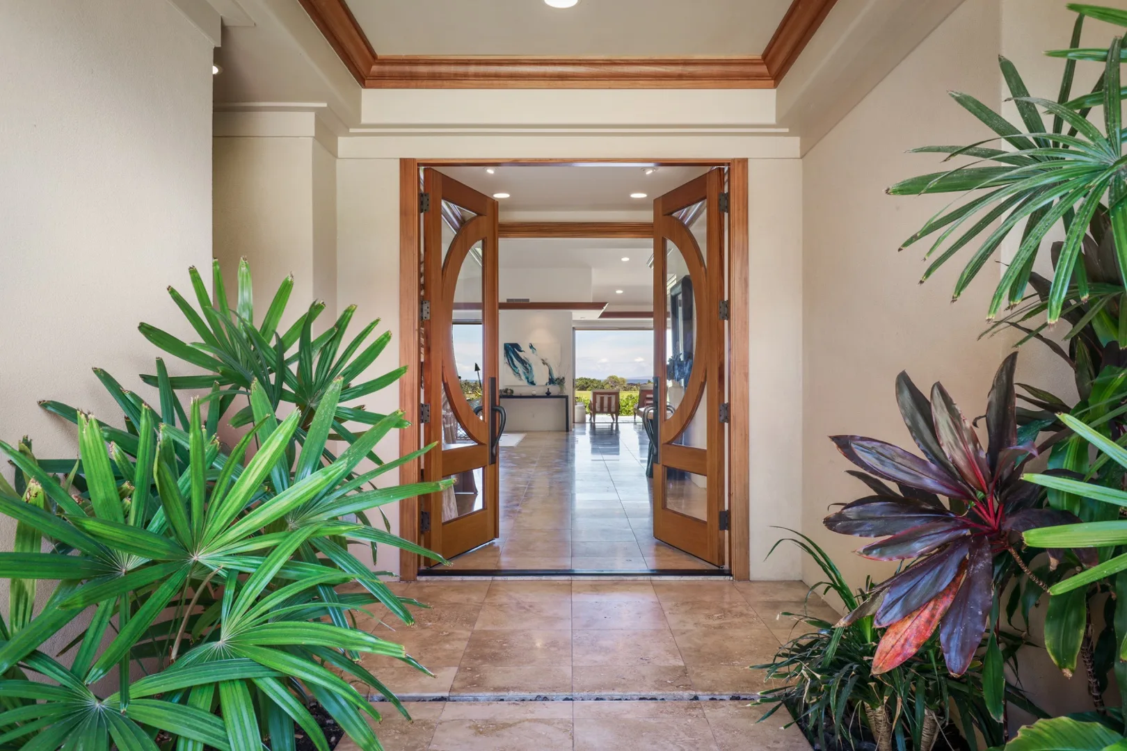 An interior hallway opens through wooden doors into a bright room with plants nearby.