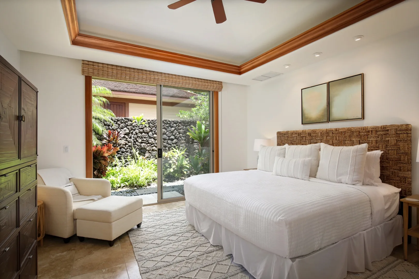 A bedroom with a large bed and sliding glass doors opening onto a garden.