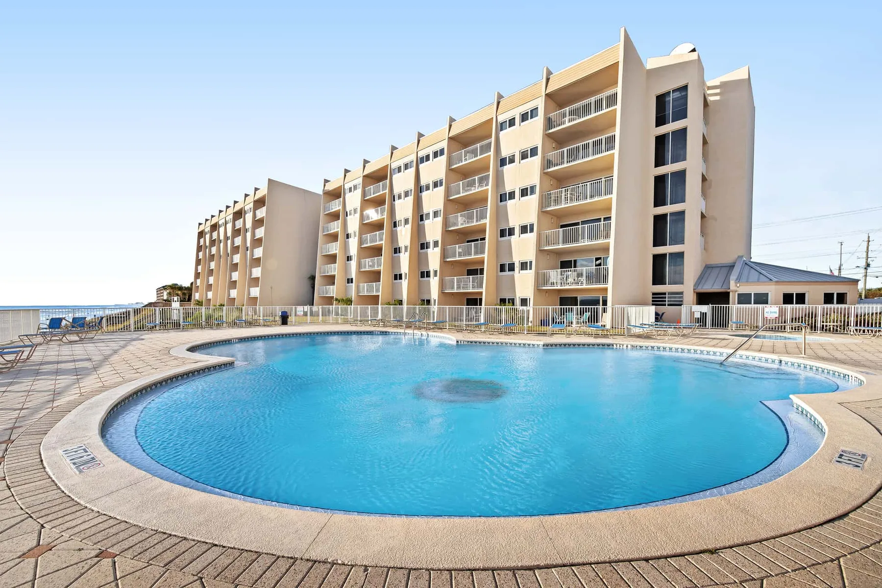 A large outdoor swimming pool sits beside a multi-story building.