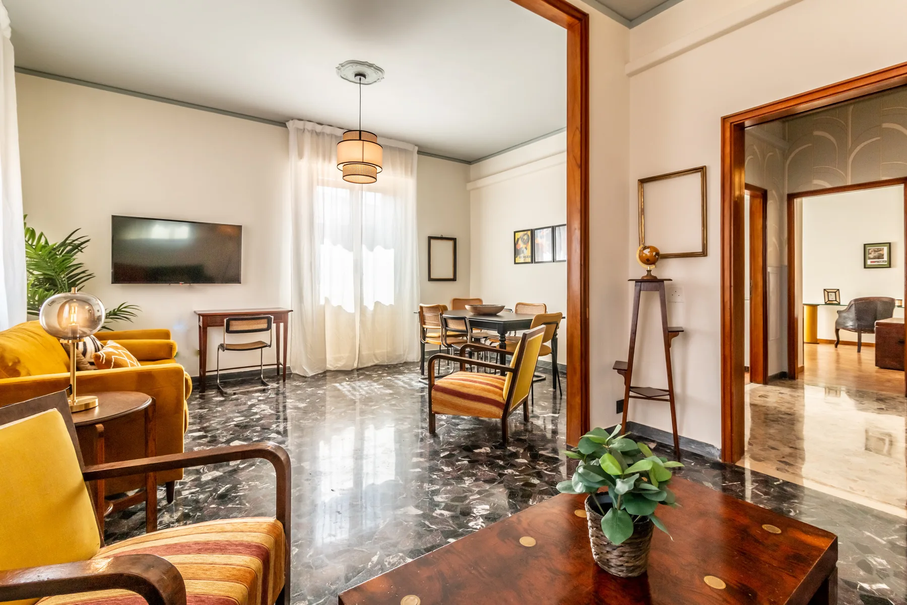 Una sala luminosa con asientos, una mesa de comedor y una planta en maceta.