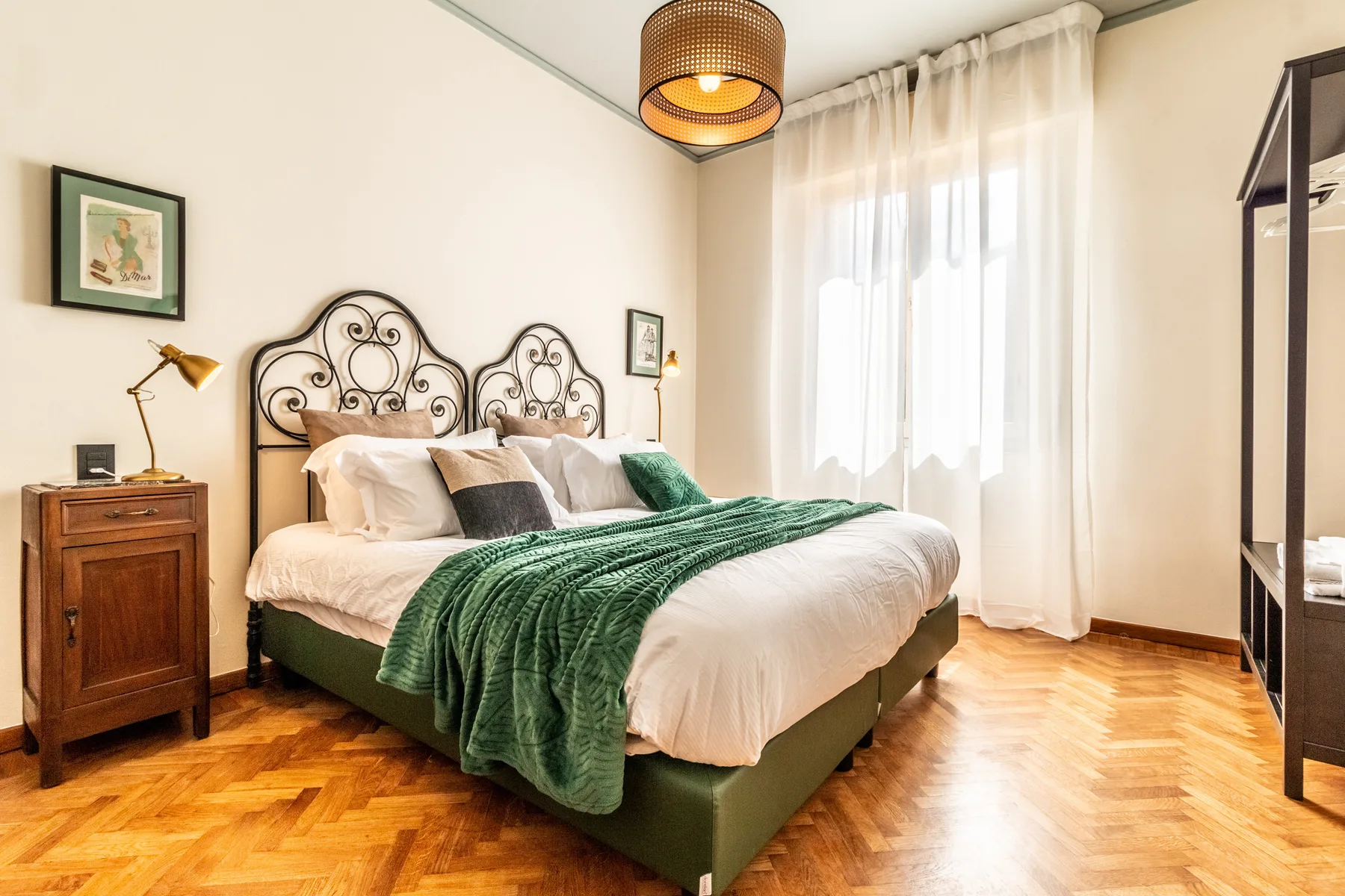 Un dormitorio con una cama doble vestida con ropa de cama blanca y una manta verde.