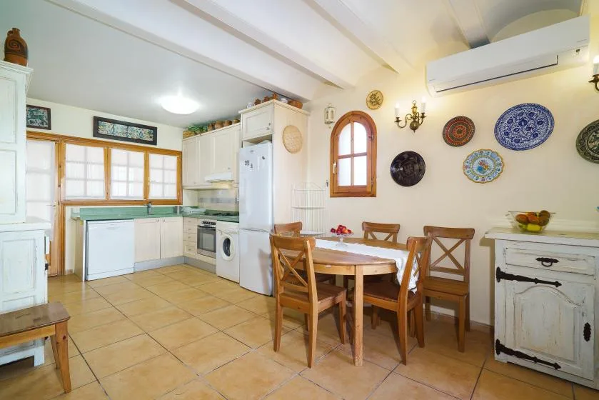 Una cocina y comedor con una mesa de madera y sillas.
