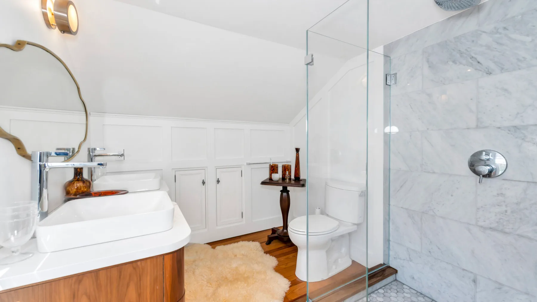 A bright bathroom with a vessel sink, toilet, and glass shower.