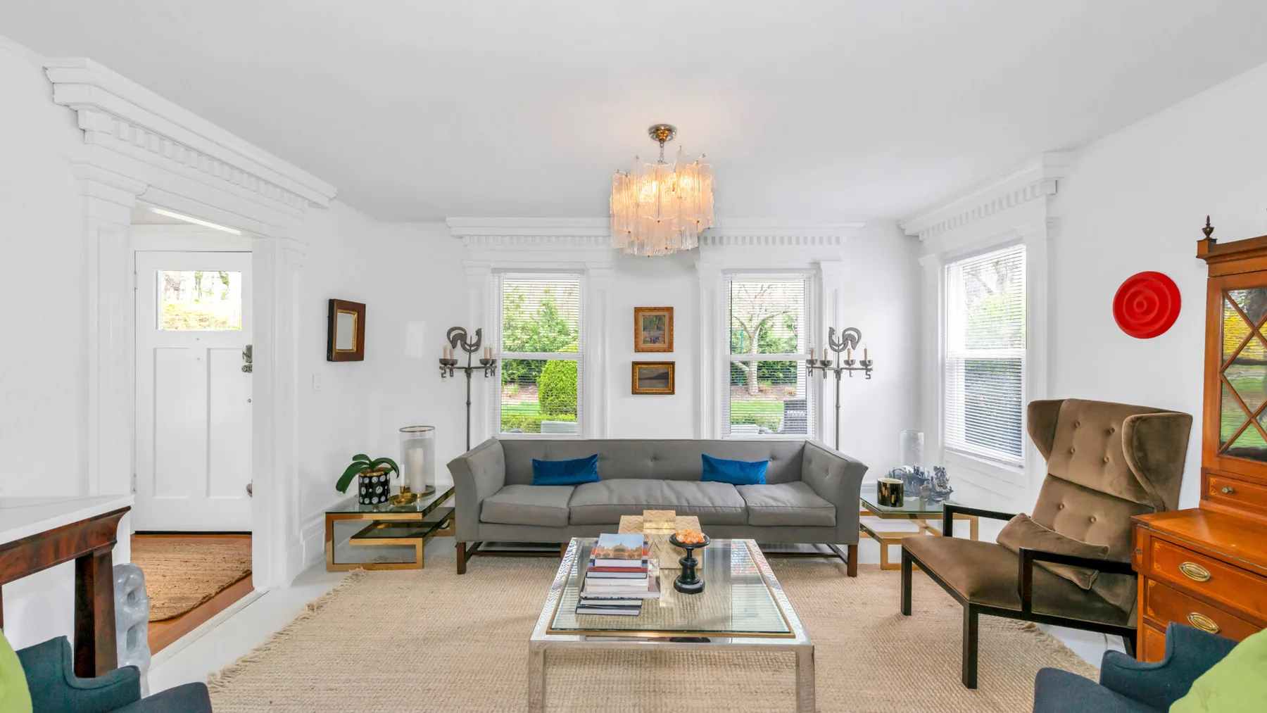 A bright living room with a gray sofa and a glass coffee table.