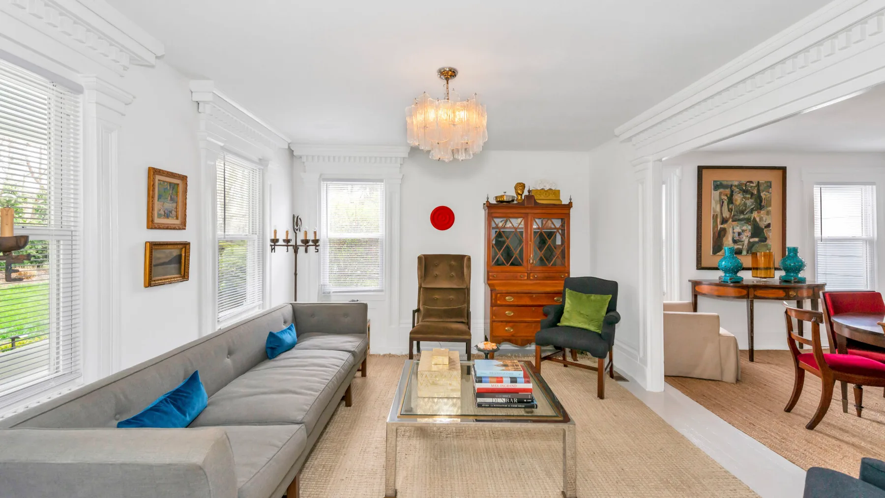 A bright living room with a long sofa and a glass coffee table.