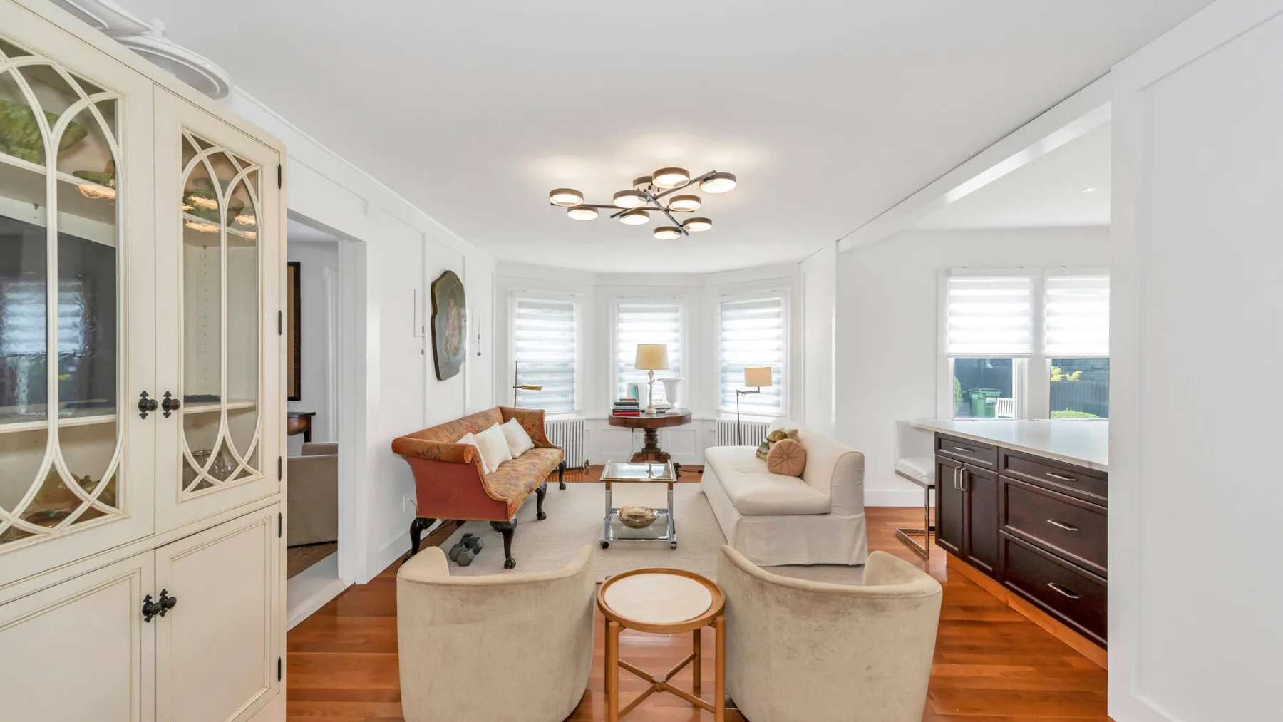 A bright living room with seating around a small coffee table and large windows.