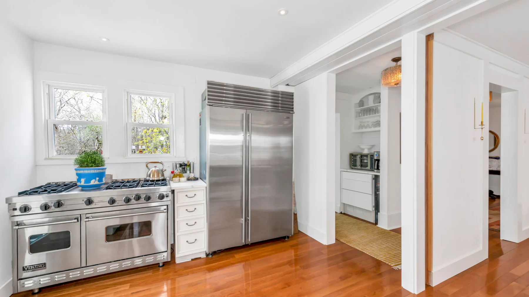 A bright kitchen with a stainless-steel range and refrigerator.