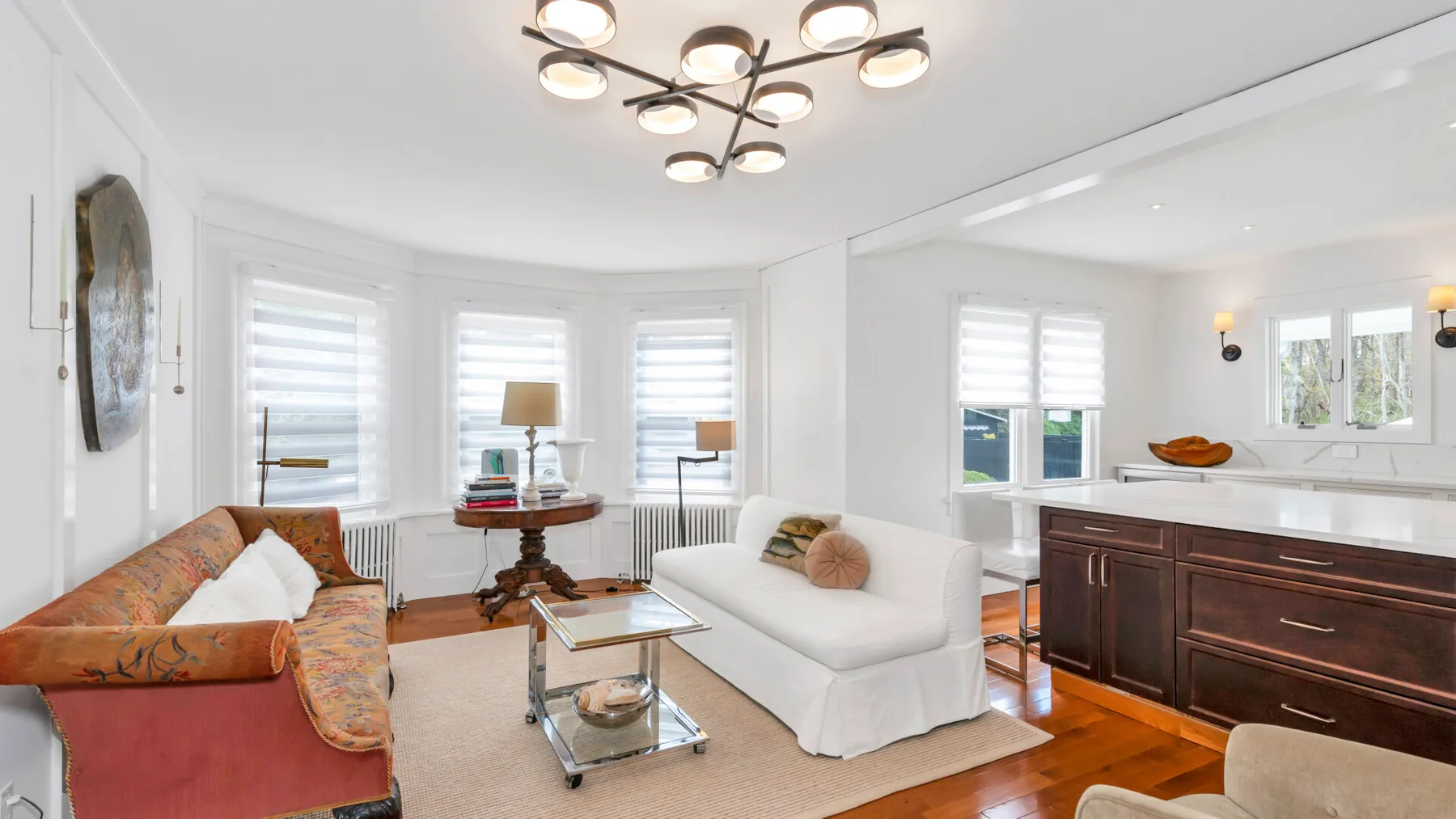A bright living room with seating, a coffee table, and a dining area.