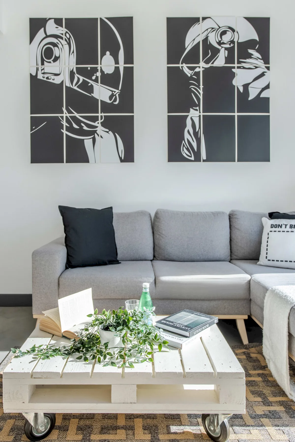 Sala de estar con sofá seccional gris, mesa de centro y arte abstracto en la pared.