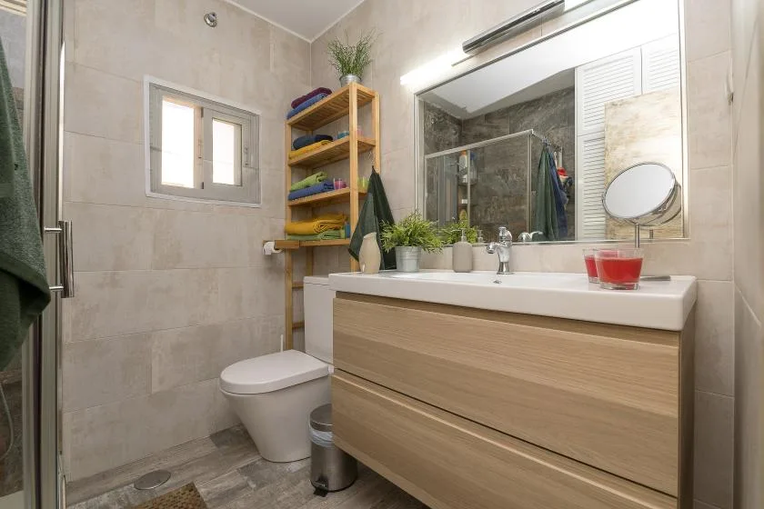 A bathroom with a long vanity, mirror, and shower.